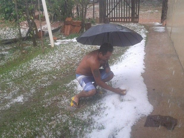 Tempestade de granizo assusta moradores de Mirandópolis - Wagner recolhe o granizo que caiu no quintal da casa dele (Foto: TEM Você)